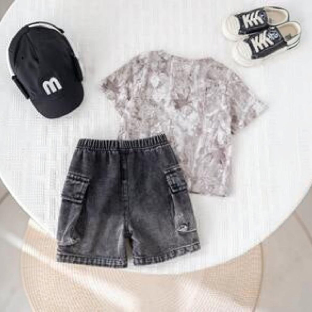 Babylove Nauru 2-piece baby boy summer outfit with grey camo t-shirt and black denim cargo shorts on a white table