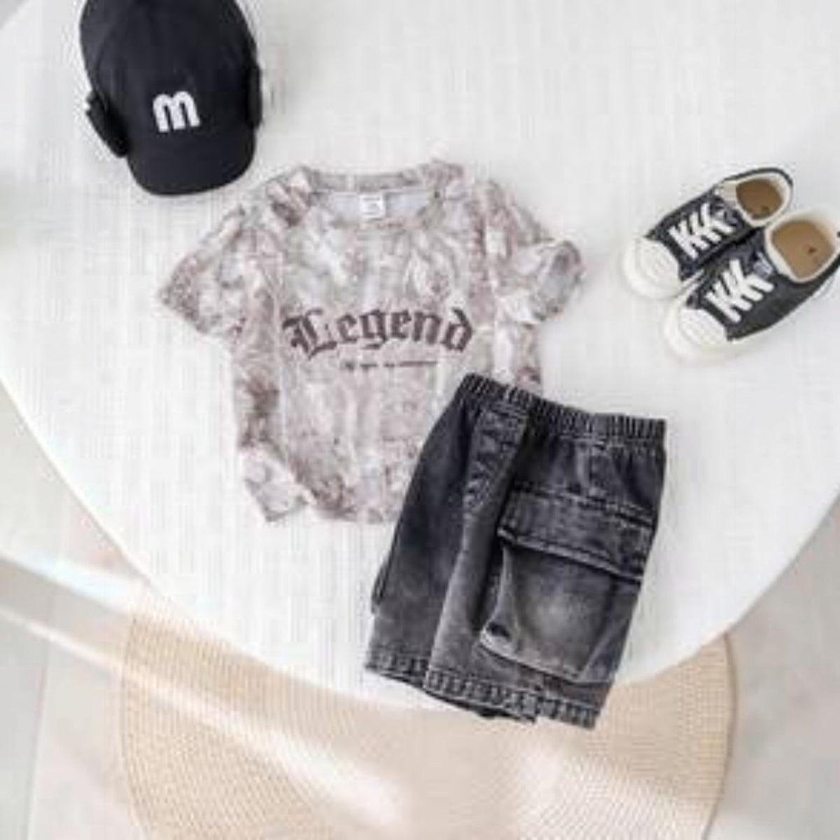 Babylove Nauru baby boy summer outfit featuring a grey camo Legend t-shirt, black denim cargo shorts, and a cap.