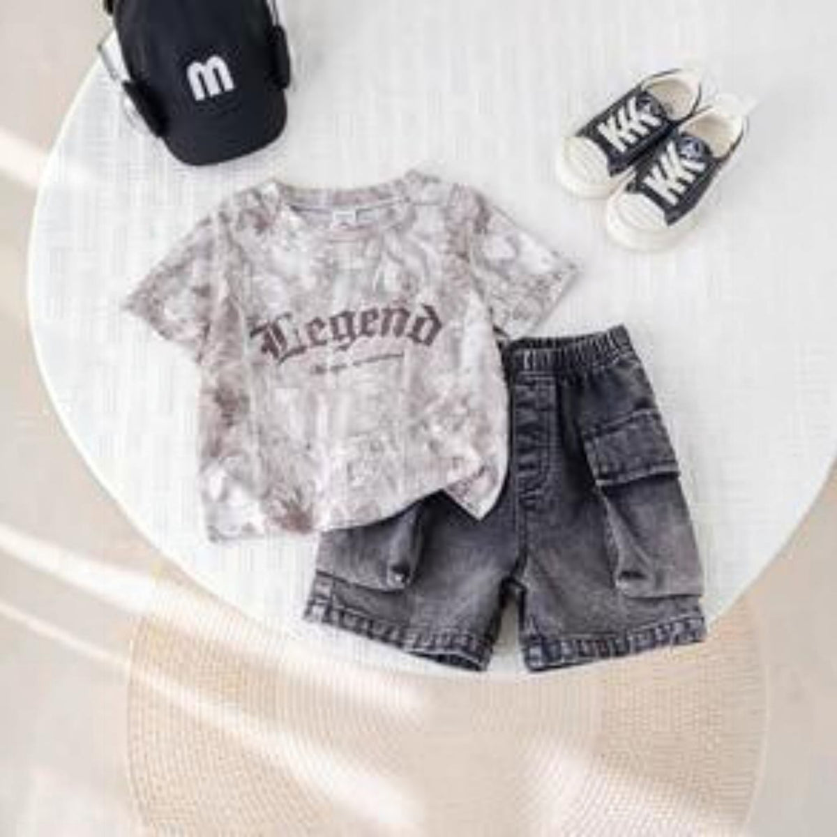 Babylove Nauru baby boy 2-piece set with grey camo Legend t-shirt and black denim cargo shorts on a white table