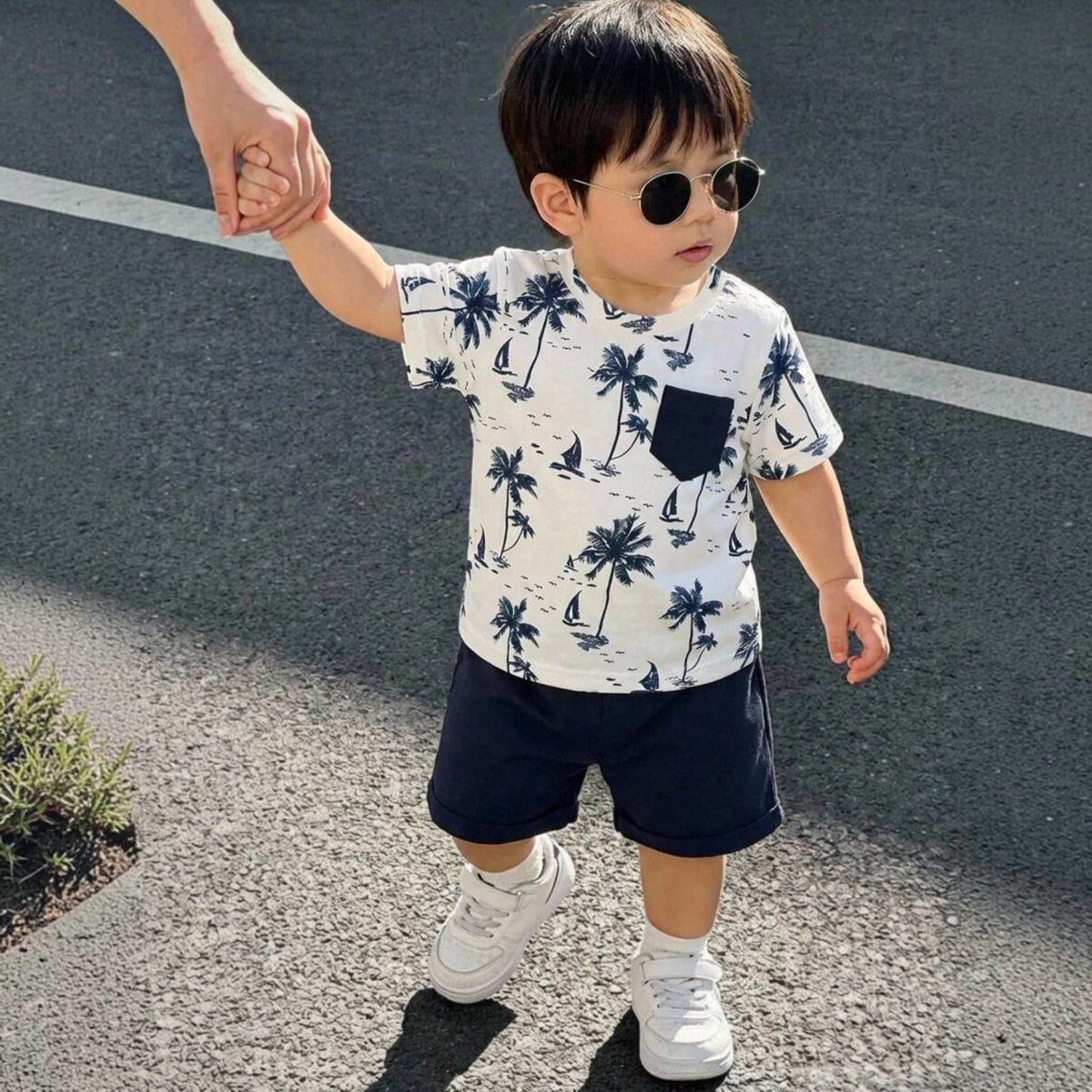 Babylove Nauru toddler boy wearing a white coconut tree print t-shirt with a navy pocket and matching navy shorts